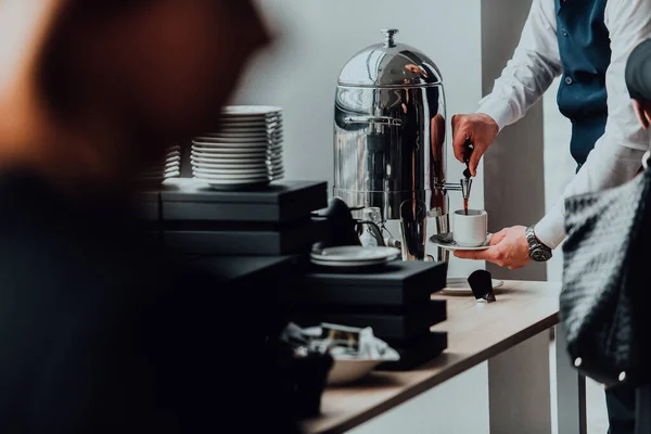 The waiter preparing coffee for hotel guests. Close up photo of service in modern hotels.