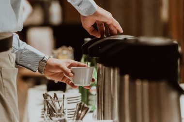 Garson otel misafirleri için kahve hazırlıyor. Modern otellerdeki servis fotoğraflarını kapat. 