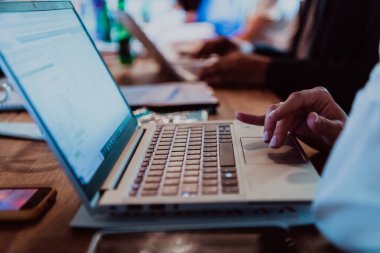 Bir kadın elinin bir seminerde dizüstü bilgisayarda kullandığı fotoğrafı kapat.. 