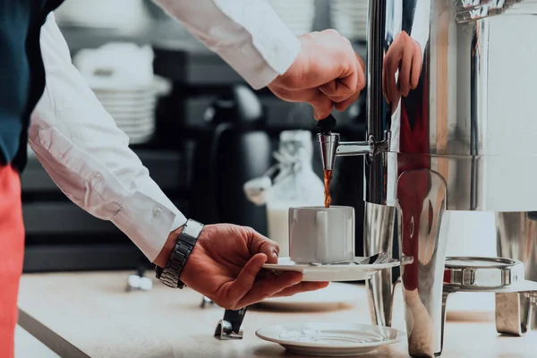 The waiter preparing coffee for hotel guests. Close up photo of service in modern hotels.