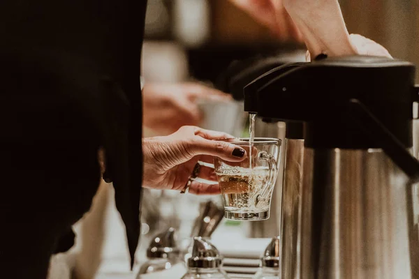 The waiter preparing coffee for hotel guests. Close up photo of service in modern hotels.