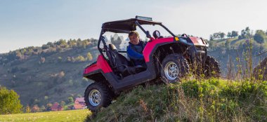 ATV motosikleti süren bir adam güzel çayır manzaraları arasında. Yüksek kalite fotoğraf