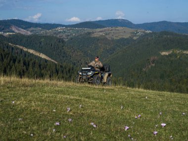 ATV motosikleti süren bir adam güzel çayır manzaraları arasında. Yüksek kalite fotoğraf
