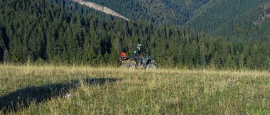 ATV motosikleti süren bir adam güzel çayır manzaraları arasında. Yüksek kalite fotoğraf