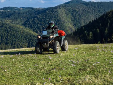 ATV motosikleti süren bir adam güzel çayır manzaraları arasında. Yüksek kalite fotoğraf