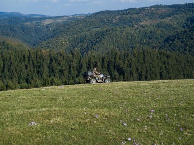 ATV motosikleti süren bir adam güzel çayır manzaraları arasında. Yüksek kalite fotoğraf