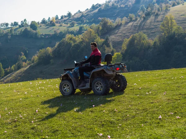 一个男人驾驶一辆四轮驱动的Atv摩托车穿过美丽的草地风景 高质量的照片 — 图库照片