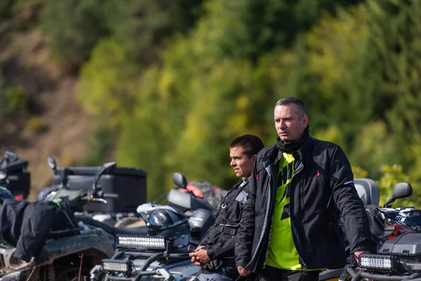 社会的な集まりの男性のグループは Atvクワッドバイクに乗る準備をしています 泥だらけの森の道を四つのAtvで一緒に乗る — ストック写真