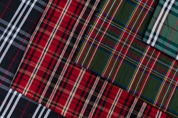 Collection of Scottish fashionable fabrics . Samples of different natural fabrics for sewing a fashion collection of clothes. Large selection of fabrics in the store or tailor warehouse. High quality