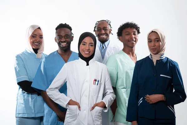 Team or group of a doctor, nurse and medical professional coworkers standing together. Portrait of diverse healthcare workers looking confident. Middle Eastern and African, Muslim medical team. High