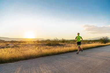 Sabahın erken saatlerinde profesyonel kıyafetlerle koşan triatloncu, maratona hazırlanıyor, spora ve bir maratonun mücadelesine hazırlanıyor.