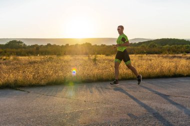 Sabahın erken saatlerinde profesyonel kıyafetlerle koşan triatloncu, maratona hazırlanıyor, spora ve bir maratonun mücadelesine hazırlanıyor.