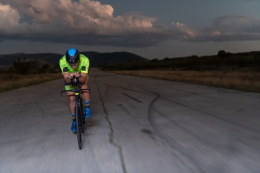 Gecenin karanlığında bisiklete binen bir triatlet maratona hazırlanmak için kendini zorluyor. Karanlığın ve motorunun ışığı arasındaki zıtlık dram hissi yaratıyor.