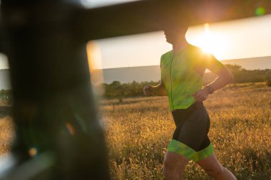 Sabahın erken saatlerinde profesyonel kıyafetlerle koşan triatloncu, maratona hazırlanıyor, spora ve bir maratonun mücadelesine hazırlanıyor.