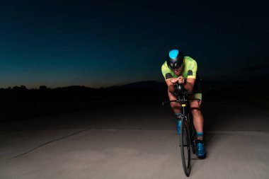 Gecenin karanlığında bisiklete binen bir triatlet maratona hazırlanmak için kendini zorluyor. Karanlığın ve motorunun ışığı arasındaki zıtlık dram hissi yaratıyor.