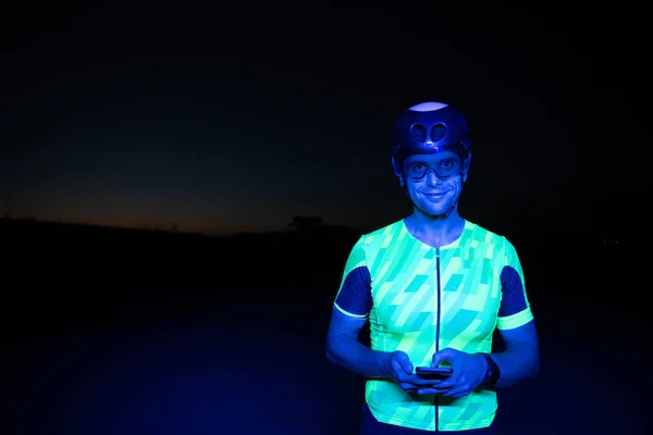 Triathlonista Korzystający Smartfona Podczas Przerwy Ciężkich Nocy Treningu Kolarskiego Wysokiej — Zdjęcie stockowe