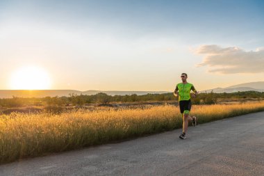 Sabahın erken saatlerinde profesyonel kıyafetlerle koşan triatloncu, maratona hazırlanıyor, spora ve bir maratonun mücadelesine hazırlanıyor.