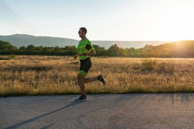 Sabahın erken saatlerinde profesyonel kıyafetlerle koşan triatloncu, maratona hazırlanıyor, spora ve bir maratonun mücadelesine hazırlanıyor.