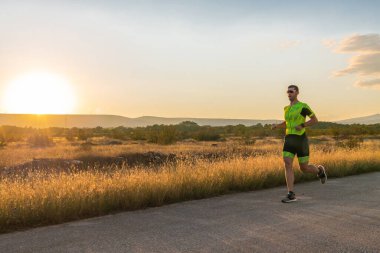 Sabahın erken saatlerinde profesyonel kıyafetlerle koşan triatloncu, maratona hazırlanıyor, spora ve bir maratonun mücadelesine hazırlanıyor.
