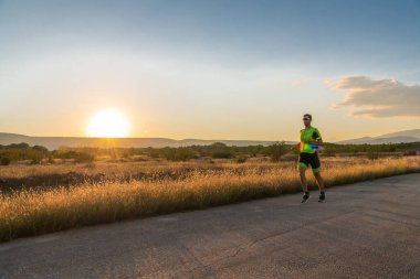 Sabahın erken saatlerinde profesyonel kıyafetlerle koşan triatloncu, maratona hazırlanıyor, spora ve bir maratonun mücadelesine hazırlanıyor.