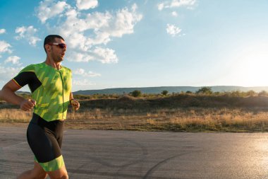 Sabahın erken saatlerinde profesyonel kıyafetlerle koşan triatloncu, maratona hazırlanıyor, spora ve bir maratonun mücadelesine hazırlanıyor.