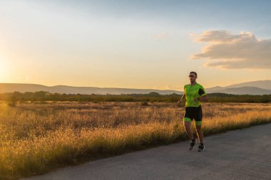 Sabahın erken saatlerinde profesyonel kıyafetlerle koşan triatloncu, maratona hazırlanıyor, spora ve bir maratonun mücadelesine hazırlanıyor.