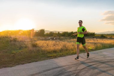 Sabahın erken saatlerinde profesyonel kıyafetlerle koşan triatloncu, maratona hazırlanıyor, spora ve bir maratonun mücadelesine hazırlanıyor.