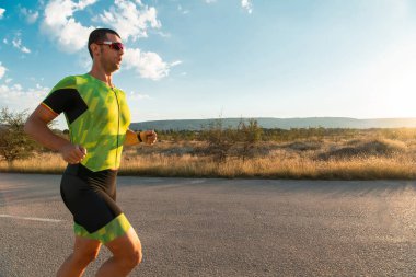 Sabahın erken saatlerinde profesyonel kıyafetlerle koşan triatloncu, maratona hazırlanıyor, spora ve bir maratonun mücadelesine hazırlanıyor.