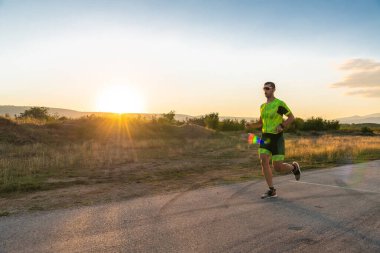 Sabahın erken saatlerinde profesyonel kıyafetlerle koşan triatloncu, maratona hazırlanıyor, spora ve bir maratonun mücadelesine hazırlanıyor.