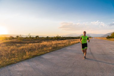 Sabahın erken saatlerinde profesyonel kıyafetlerle koşan triatloncu, maratona hazırlanıyor, spora ve bir maratonun mücadelesine hazırlanıyor.