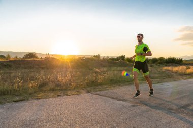 Sabahın erken saatlerinde profesyonel kıyafetlerle koşan triatloncu, maratona hazırlanıyor, spora ve bir maratonun mücadelesine hazırlanıyor.