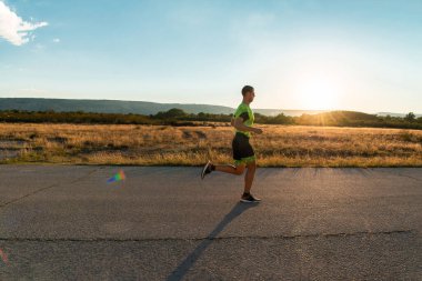 Sabahın erken saatlerinde profesyonel kıyafetlerle koşan triatloncu, maratona hazırlanıyor, spora ve bir maratonun mücadelesine hazırlanıyor.