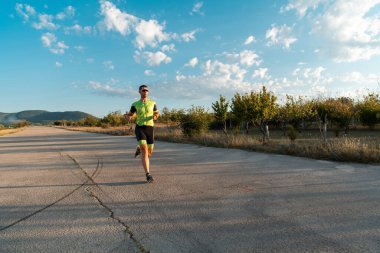 Sabahın erken saatlerinde profesyonel kıyafetlerle koşan triatloncu, maratona hazırlanıyor, spora ve bir maratonun mücadelesine hazırlanıyor.