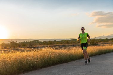 Sabahın erken saatlerinde profesyonel kıyafetlerle koşan triatloncu, maratona hazırlanıyor, spora ve bir maratonun mücadelesine hazırlanıyor.
