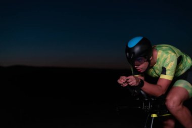 Gecenin karanlığında bisiklete binen bir triatlet maratona hazırlanmak için kendini zorluyor. Karanlığın ve motorunun ışığı arasındaki zıtlık dram hissi yaratıyor.