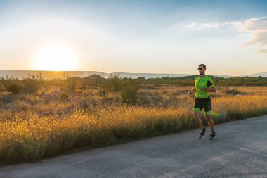Sabahın erken saatlerinde profesyonel kıyafetlerle koşan triatloncu, maratona hazırlanıyor, spora ve bir maratonun mücadelesine hazırlanıyor.