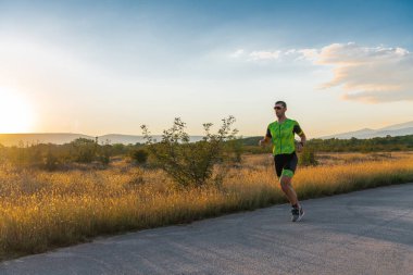 Sabahın erken saatlerinde profesyonel kıyafetlerle koşan triatloncu, maratona hazırlanıyor, spora ve bir maratonun mücadelesine hazırlanıyor.