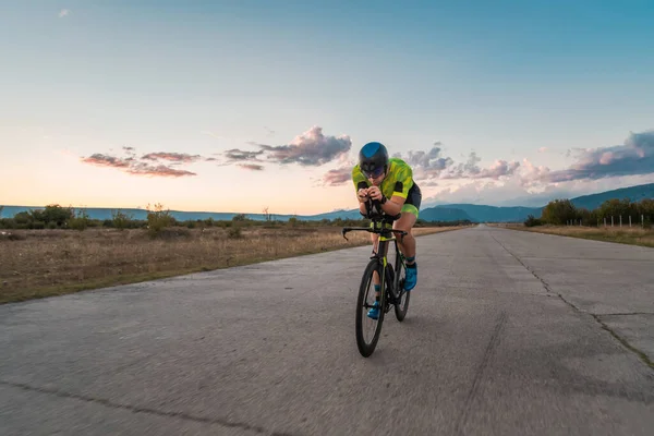 日落时分 他骑自行车 准备参加马拉松比赛 温暖的天空为他坚定而专注的努力提供了美丽的背景 — 图库照片