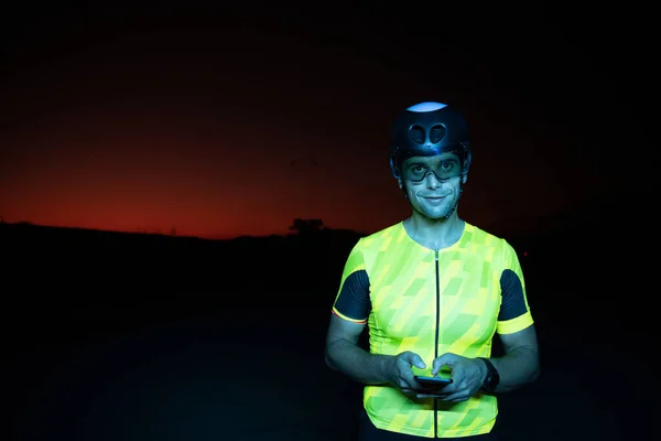厳しい夜のサイクリングトレーニングから休憩を取りながら スマートフォンを使用してトライアスロン選手 高品質の写真 — ストック写真