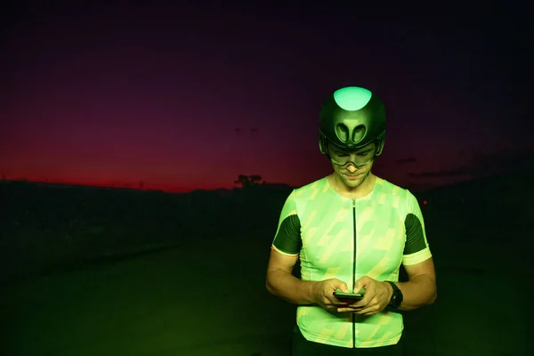 Egy Triatlonos Okostelefont Használ Miközben Szünetelteti Kemény Éjszakai Kerékpáros Edzést — Stock Fotó