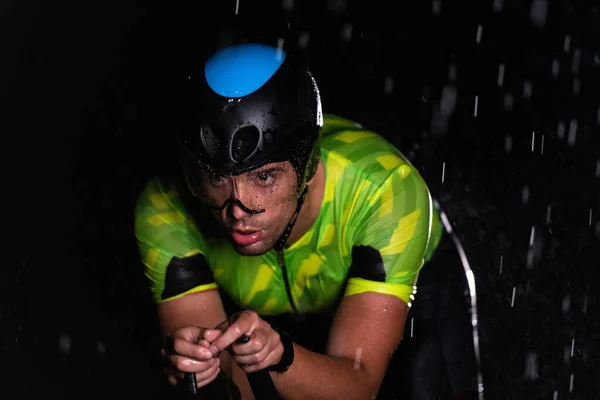 맞으며 자전거를 밤새도록 질주하는 트라이애슬론 선수가 다가오는 마라톤을 준비하고 있습니다 — 스톡 사진