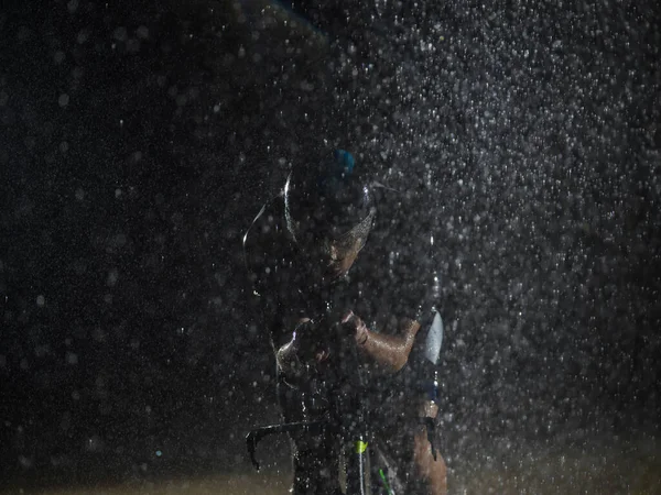 一位三人组运动员冒着雨淋了个通宵 准备迎接即将到来的马拉松比赛 前景朦胧的雨滴和背景中阴郁而忧郁的气氛又增添了 — 图库照片