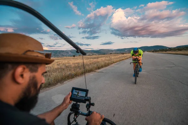 Videographer Recording Triathlete Riding His Bike Preparing Upcoming Marathon Athletes — Stock Photo, Image