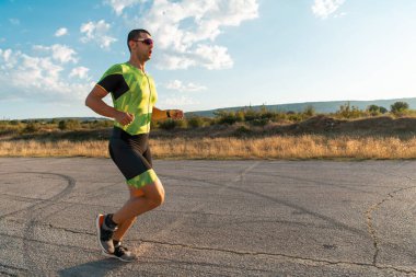 Sabahın erken saatlerinde profesyonel kıyafetlerle koşan triatloncu, maratona hazırlanıyor, spora ve bir maratonun mücadelesine hazırlanıyor.