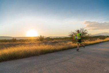 Sabahın erken saatlerinde profesyonel kıyafetlerle koşan triatloncu, maratona hazırlanıyor, spora ve bir maratonun mücadelesine hazırlanıyor.