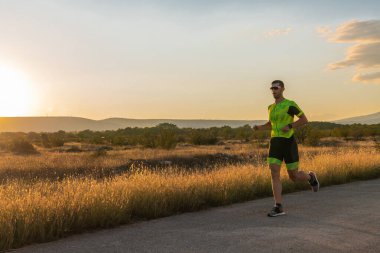 Sabahın erken saatlerinde profesyonel kıyafetlerle koşan triatloncu, maratona hazırlanıyor, spora ve bir maratonun mücadelesine hazırlanıyor.