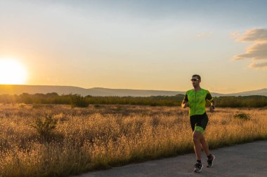 Sabahın erken saatlerinde profesyonel kıyafetlerle koşan triatloncu, maratona hazırlanıyor, spora ve bir maratonun mücadelesine hazırlanıyor.