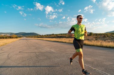 Sabahın erken saatlerinde profesyonel kıyafetlerle koşan triatloncu, maratona hazırlanıyor, spora ve bir maratonun mücadelesine hazırlanıyor.