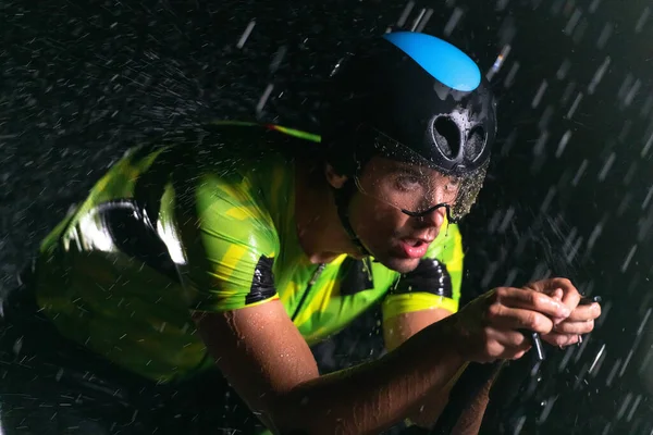 맞으며 자전거를 밤새도록 질주하는 트라이애슬론 선수가 다가오는 마라톤을 준비하고 있습니다 — 스톡 사진