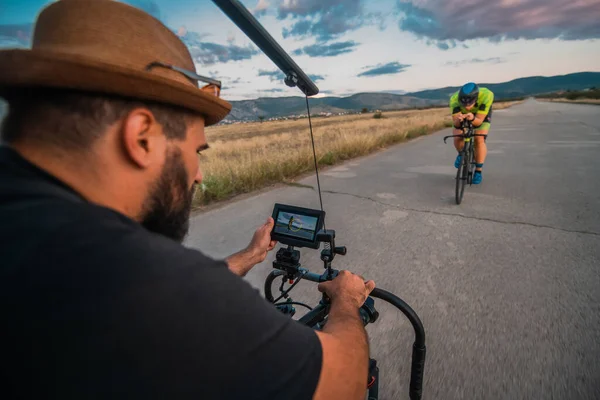 Seorang Videografer Merekam Seorang Atlet Triatlon Yang Sedang Mengendarai Sepedanya — Stok Foto
